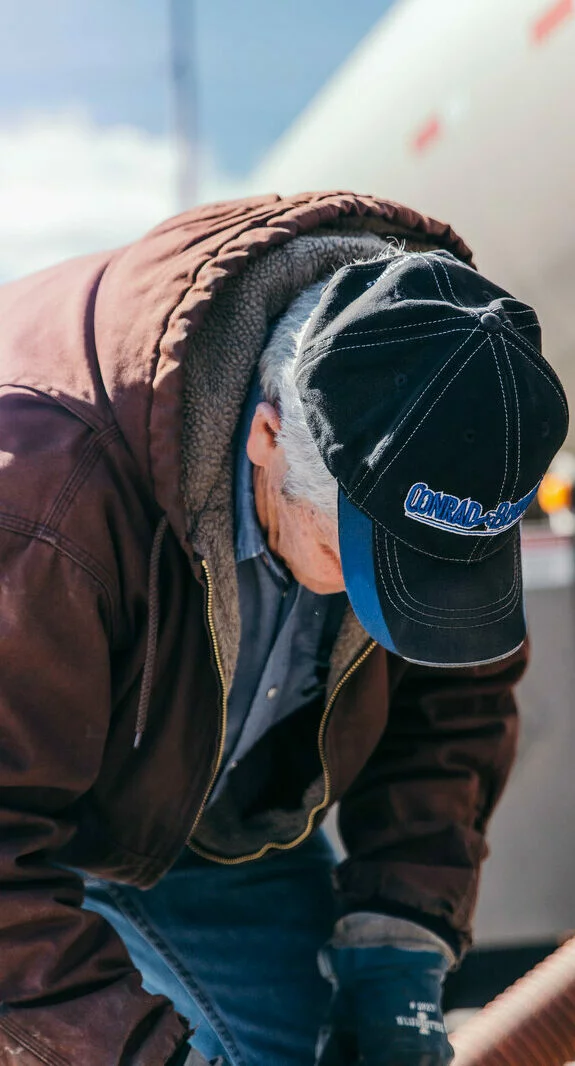 Conrad and Bischoff employee wearing a company hat during work.